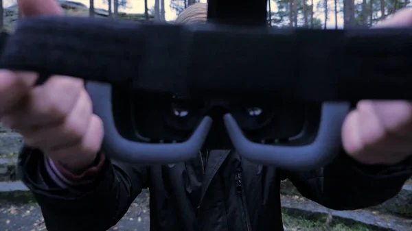 Young Man geven een Virtual Reality Headset in het park. Young Man geven een Virtual Reality Headset in de outdoor — Stockfoto