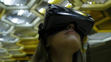 Genç bir kadının Vr bardaklarda kapatın. O ne o görerek hayran. Bir arka plan karşı duruyor