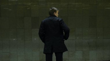 Metro istasyonunda yalnız genç adam arkadan. Genç adam bir tren metro, dikiz bekler