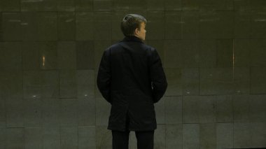 Metro istasyonunda yalnız genç adam arkadan. Genç adam bir tren metro, dikiz bekler