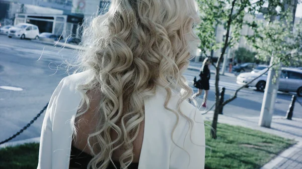 Привлекательная блондинка, деловая женщина, гуляющая по городу. Деловая женщина, гуляющая по городу спиной к камере — стоковое фото