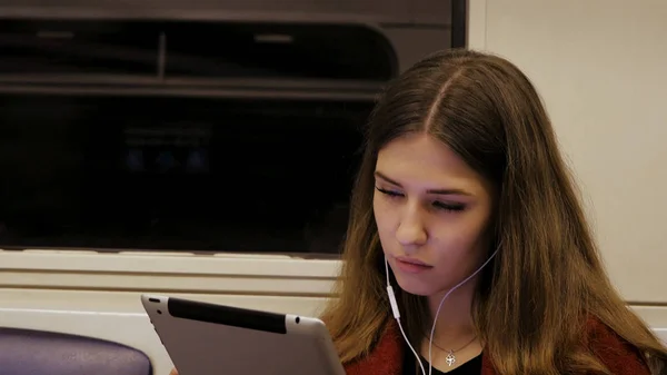 Giovane donna d'affari viaggiando treno tablet computer. Giovane donna in metropolitana lavora nel tablet — Foto Stock
