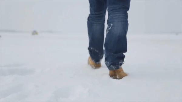 Muž v sněhu. Muž na sněhu, stopy ve sněhu, vzadu. Muž chodí v zimě v poli — Stock fotografie