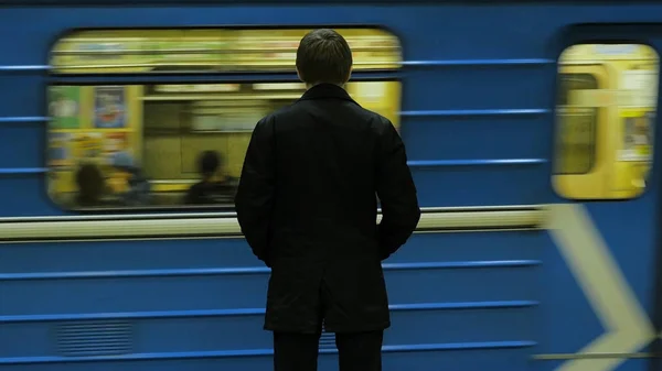 地下鉄駅で後ろから孤独な青年。若い男は、地下鉄、リアビューで列車を待つ — ストック写真