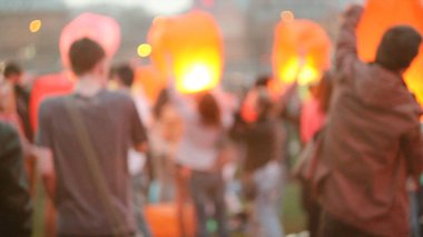 Altında gelen genç kadın yanan Çince fener tutarak şehirde olmak istiyorum akşam gökyüzü için başlatmak. Genç kadın bir gökyüzü fener başlattı