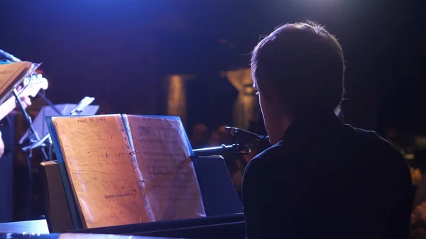 Beau jeune homme qui fait de la musique pour piano, vue de dos. Vue arrière de l'interprète de musique jouant du piano à l'hôtel de luxe — Photo