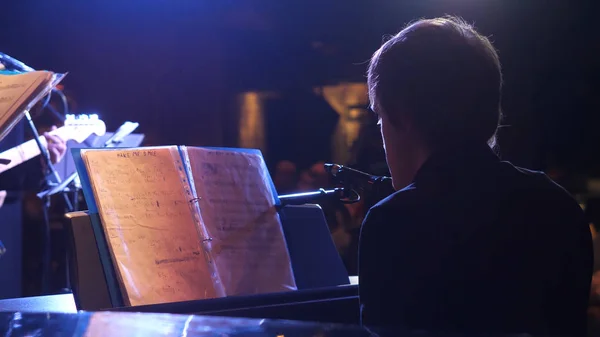 Knappe jonge man maken pianomuziek, achteraanzicht. Achteraanzicht van muziek performer pianospelen in luxehotel — Stockfoto