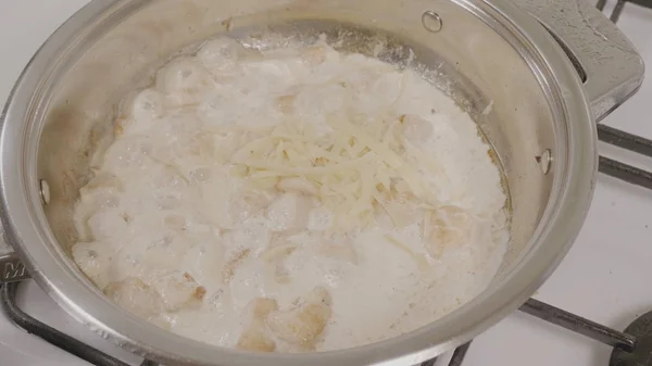 Üstten Görünüm peynir tavuk tavayla ekleme. Bir tavada kızartma tavuk. Bir gaz soba sıcak bir tava pişirme tavuk eti closeup — Stok fotoğraf