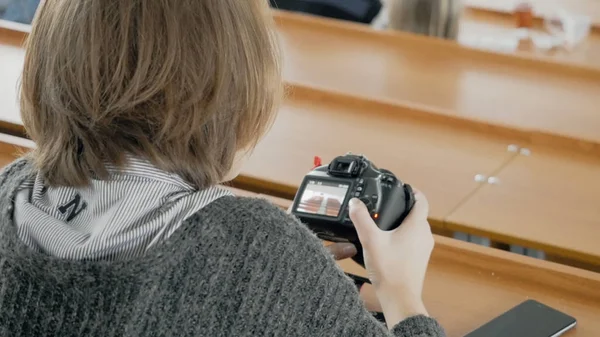 Jovem fotógrafo feliz assistindo fotos na câmera. Jovem mulher assistindo fotos na câmera na sala — Fotografia de Stock