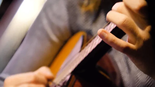Closeup bela guitarra acústica sendo tocada por mulher sentada, conceito músico. Mulher tocando a guitarra close-up — Fotografia de Stock