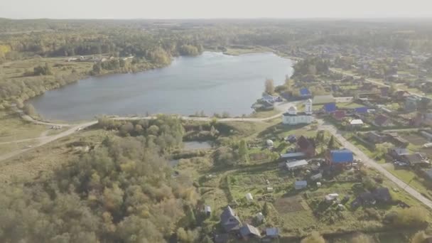 Vista aérea da aldeia europeia perto da lagoa. Bela vista aérea de Color Lake e aldeia com igreja. Vista superior da aldeia e lagoa — Vídeo de Stock