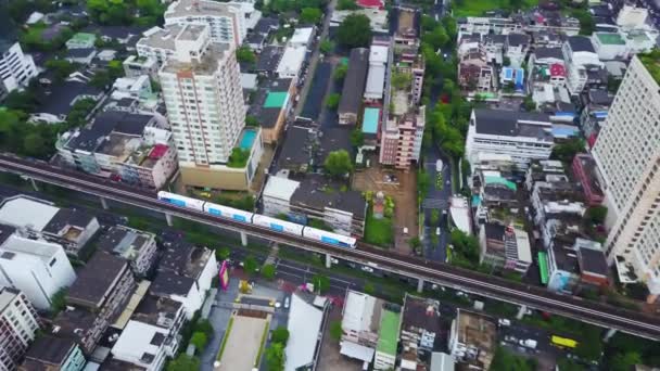 Blick von oben auf die Stadt und den Himmelszug von Bangkok, der vom Bahnhof abfährt. Blick von oben auf moderne Städte und Bahnhöfe — Stockvideo