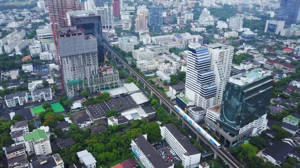 Top view city and Sky Train of Bangkok going out from station. Top view of modern city and traine going — Stock Photo, Image