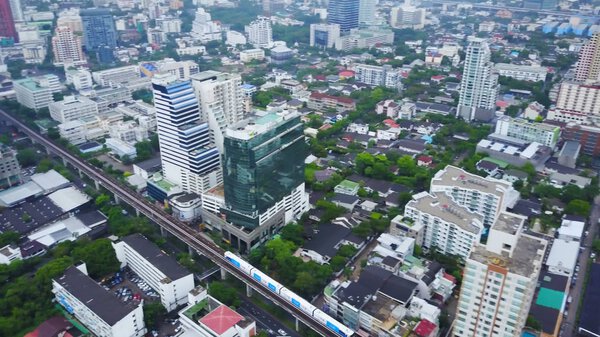 Top view city and Sky Train of Bangkok going out from station. Top view of modern city and traine going.