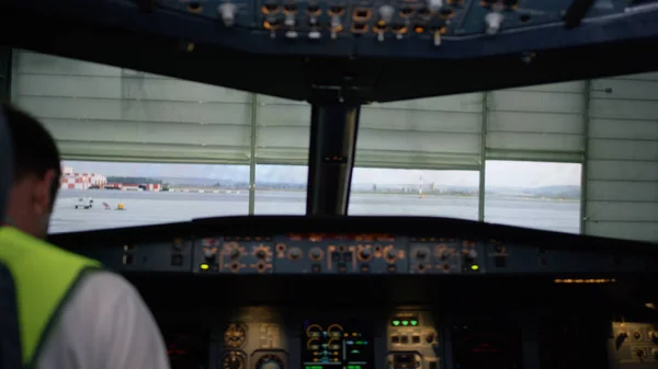 Un piloto revisando instrumentos en una cabina de avión. Vista trasera de los controles de operación piloto del jet corporativo. el piloto comprueba todos los sistemas. Vista trasera de los controles de funcionamiento piloto y copiloto de — Foto de Stock