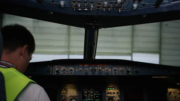 En pilot kontrollera instrument i ett plan cockpit. Bakifrån av pilot manöverorganen av corporate jet. piloten kontrollerar alla system. Bakifrån av pilot och andrepilot manöverorganen av — Stockfoto