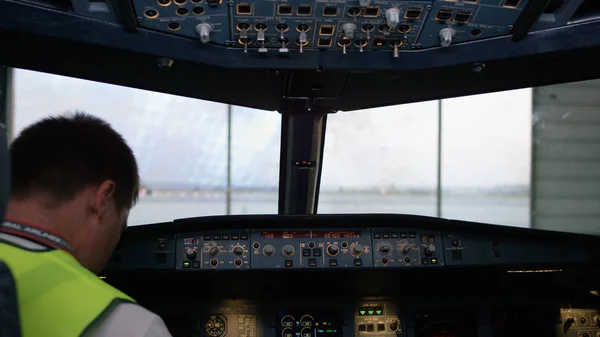 Pilot, sprawdzanie przyrządów kokpit samolotu. Widok z tyłu pilota sterujących firmy jet. pilot sprawdza wszystkie systemy. Widok z tyłu pilota i copilot sterujących z — Zdjęcie stockowe