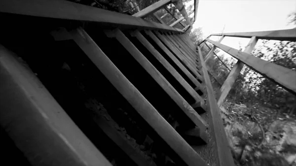 Vista inferior da escada velha céu fundo preto e branco. Filmagem. Thai estilo escada casa de madeira. Ponte de madeira velha no rio — Fotografia de Stock