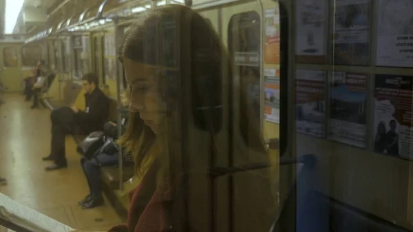 Hermosa chica leyendo un libro en tren en el metro. Adolescente chica leer un libro en tren — Foto de Stock