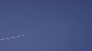 Büyük yolcu süpersonik uçak için açık mavi gökyüzü, beyaz uzun iz bırakarak yüksekten uçuyor. Mavi bir gökyüzü beyaz bulutlarda uçan uçak. Mavi gökyüzü uçan uçak