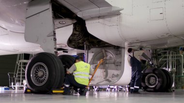 Muayene ve uçak önce hazırlama çıkar. Yolcu uçakları şasi, hangar uçuş öncesi bakım. Havaalanı işçilerin mekanik