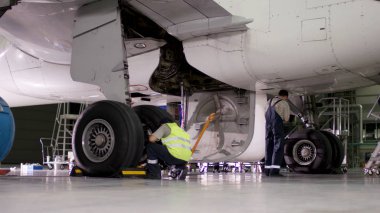 Muayene ve uçak önce hazırlama çıkar. Yolcu uçakları şasi, hangar uçuş öncesi bakım. Havaalanı işçilerin mekanik