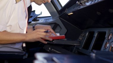 Yan görünüm denetimleri kurumsal Jet işletim pilot. Kaptan uçak kokpit, uçak kalkışa hazırlanıyor. Onun pilot apoletler üzerinde duruluyor.