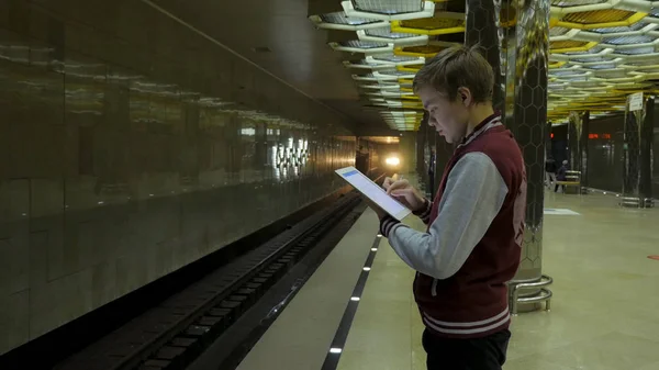 Man using touchpad or smartphone when he waits for train at subway station. Businessman using Wireless Digital Tablet PC computer at Train, Railway or Subway Station in Modern City — Stock Photo, Image