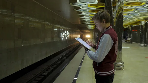 Man using touchpad or smartphone when he waits for train at subway station. Businessman using Wireless Digital Tablet PC computer at Train, Railway or Subway Station in Modern City — Stock Photo, Image