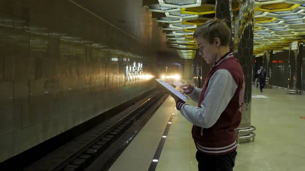 Man using touchpad or smartphone when he waits for train at subway station. Businessman using Wireless Digital Tablet PC computer at Train, Railway or Subway Station in Modern City — Stock Photo, Image