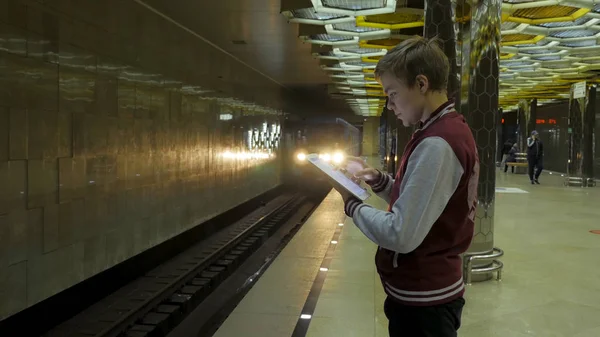 Man using touchpad or smartphone when he waits for train at subway station. Businessman using Wireless Digital Tablet PC computer at Train, Railway or Subway Station in Modern City — Stock Photo, Image