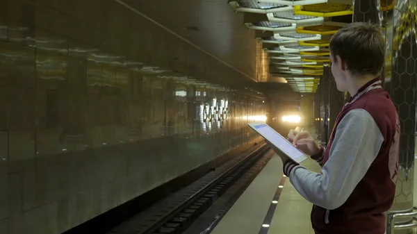 Man using touchpad or smartphone when he waits for train at subway station. Businessman using Wireless Digital Tablet PC computer at Train, Railway or Subway Station in Modern City — Stock Photo, Image