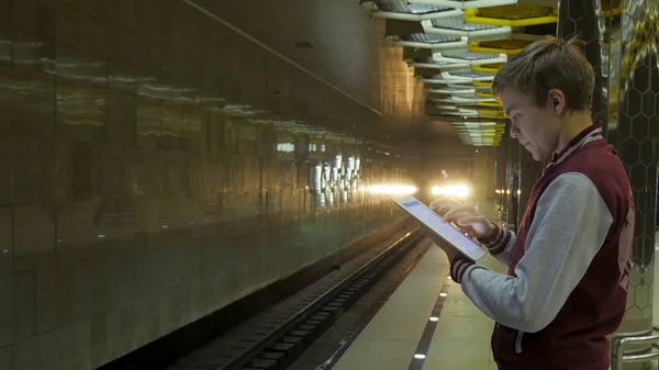 Man using touchpad or smartphone when he waits for train at subway station. Businessman using Wireless Digital Tablet PC computer at Train, Railway or Subway Station in Modern City — Stock Photo, Image