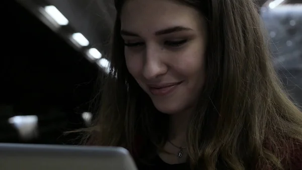 Ragazza che usa un tablet e aspetta il treno alla stazione della metropolitana. ragazza bruna rimane in metropolitana e utilizzando touchpad. gadget alla moda. Il concetto è sempre in contatto . — Foto Stock