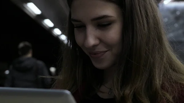 Ragazza che usa un tablet e aspetta il treno alla stazione della metropolitana. ragazza bruna rimane in metropolitana e utilizzando touchpad. gadget alla moda. Il concetto è sempre in contatto . — Foto Stock