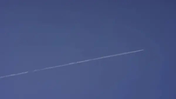 Grande aereo supersonico passeggero che vola alto nel cielo blu chiaro, lasciando lunghe tracce bianche. Aereo che vola in nuvole bianche in un cielo blu. Aereo che vola cielo blu — Foto Stock