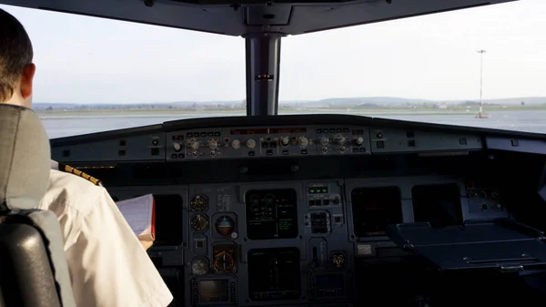 Dikiz kurumsal jet kontrol işletim pilot. Kaptan uçak kokpit, uçak kalkışa hazırlanıyor. Onun pilot apoletler üzerinde duruluyor. — Stok fotoğraf