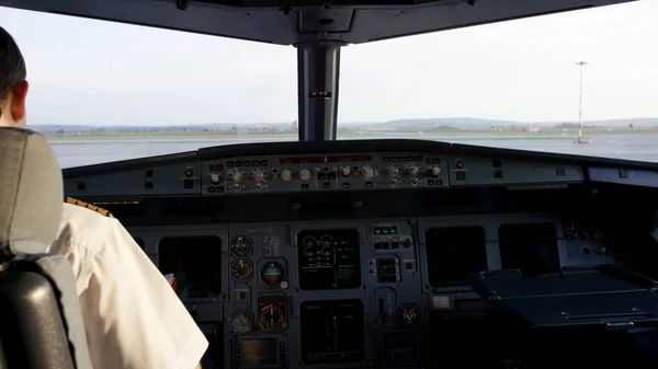 Visão traseira dos controles de operação do piloto do jato corporativo. Capitão no cockpit da aeronave, a preparar-se para a partida do voo. Concentrando-se em seus epauletos piloto . — Fotografia de Stock