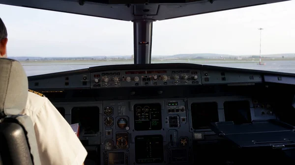 Visão traseira dos controles de operação do piloto do jato corporativo. Capitão no cockpit da aeronave, a preparar-se para a partida do voo. Concentrando-se em seus epauletos piloto . — Fotografia de Stock