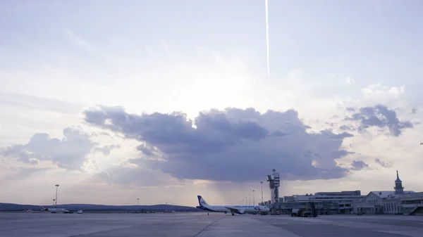 Parking aérien commercial à l'aéroport. Parking commercial pour avions à l'aéroport - vue latérale, avec cône de circulation. Avion blanc dans le parking de l'aéroport — Photo