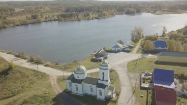 Avrupa Köyü gölet yakınındaki hava görünümünü. Renk göl ve kilise ile köy güzel havadan görünümü. Köy ve gölet Üstten Görünüm
