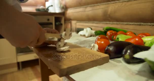 Kockar händer. Mannen i vita kläder hacka grönsaker. Färsk paprika, tomat, gurka och grönt på bakgrunden — Stockvideo