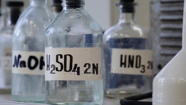 Lahví řešení uložena na polici v laboratoři. Lahve s chemické roztoky Naoh, H2so4 a Hno3. Kyselina sírová, hydroxid sodný, kyselina dusičná — Stock video