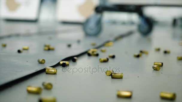 Obrovské množství nábojnice od kulek, které leží na podlaze v pokoji. Hrozné, fotografování v interiérech po které tam byla spousta nábojnice od odrážky — Stock video