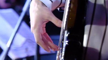 Ustaca, ustaca oyun üzerinde bir electroguitar. Adam yakın bir el bir electroguitar üzerinde çalış