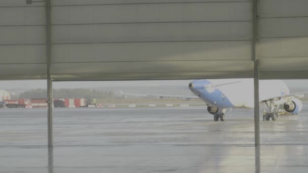 Ekaterimburgo, Rusia - Agosto de 2017: El avión en el hangar, detrás de todo el avión y la pasarela. Avión de pasajeros color blanco. Avión de pasajeros en el hangar — Vídeo de stock