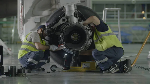 Vervanging landingsgestel. Personeel werkt heeft gewerkt om te herstellen van het chassis van een passagiersvliegtuig — Stockfoto