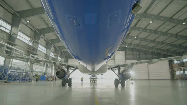 Avión en hangar, vista trasera de aviones y luz desde ventanas. Aviones de pasajeros grandes en un hangar en mantenimiento de servicio — Foto de Stock