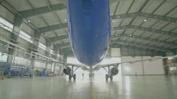Avion dans le hangar, vue arrière de l'avion et lumière des fenêtres. Grands avions de passagers dans un hangar sur la maintenance en service — Photo