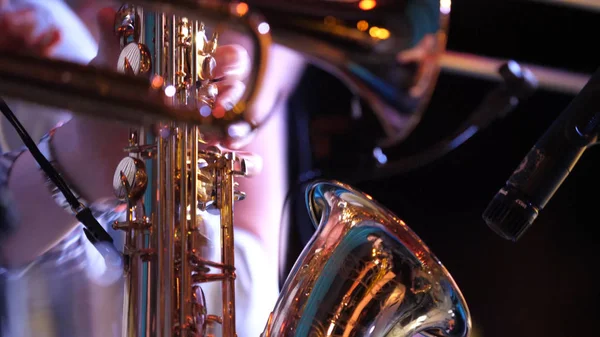 Pipes in the hands of musicians. Musicians playing wind instruments